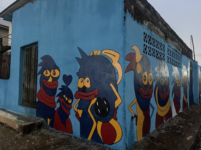 A blue wall painted with several Sprotos
