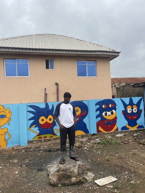 A man standing in front of a wall of painted Sprotos