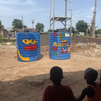 Two water tanks on a tower painted with Sproto Gremlins at Onipanu village, Nigeria